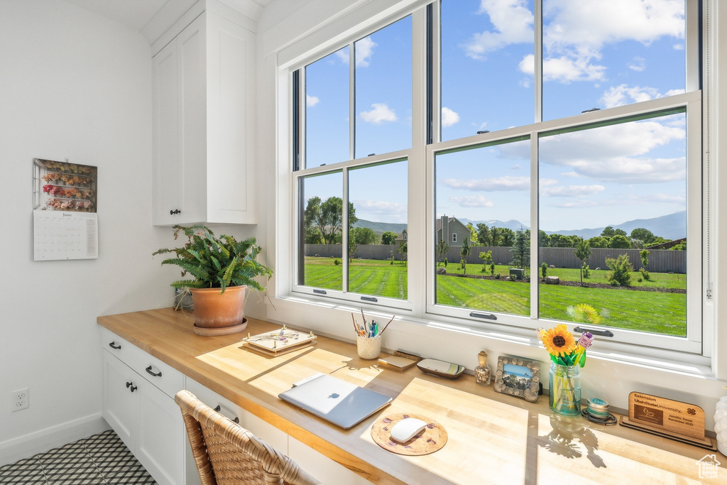 Kitchen featuring white cabinets, tile floors, and butcher block counters