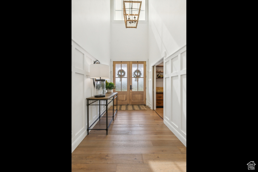 Foyer entrance featuring wood-type flooring, a high ceiling, and french doors