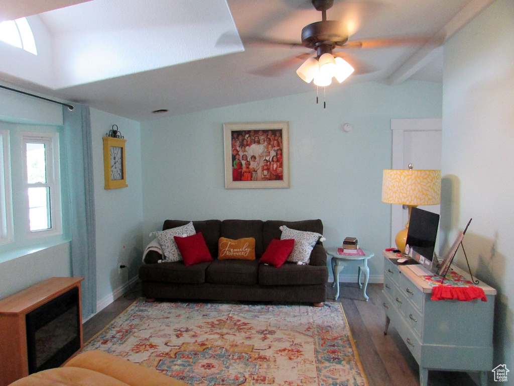 Living room with hardwood / wood-style flooring, lofted ceiling with beams, and ceiling fan