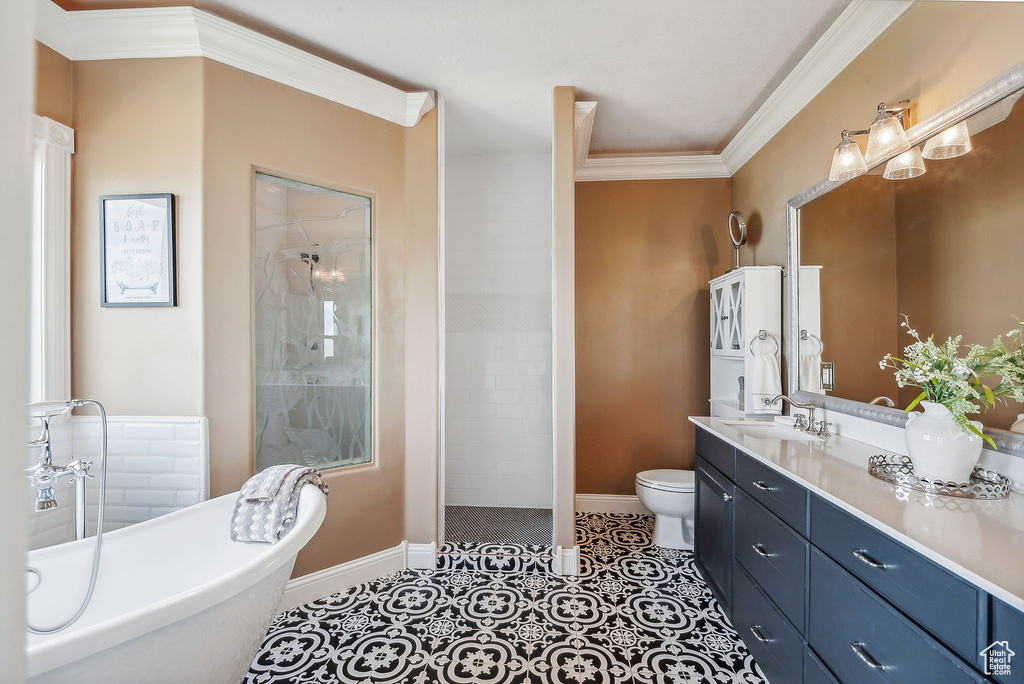 Full bathroom with tile patterned flooring, crown molding, toilet, vanity, and shower with separate bathtub