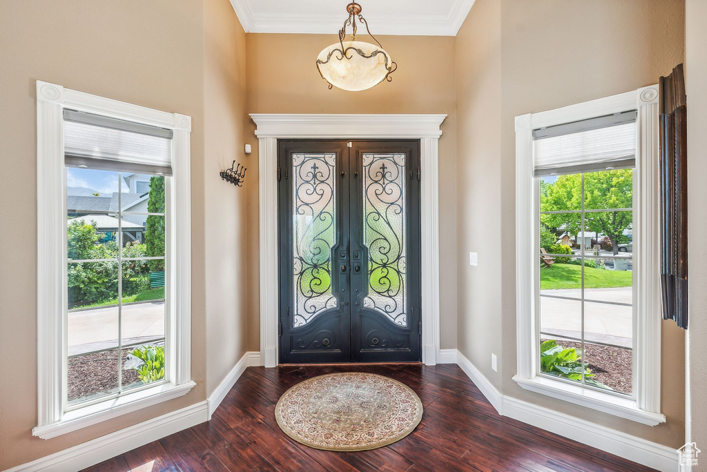 Foyer featuring dark hardwood / wood-style flooring, french doors, and crown molding