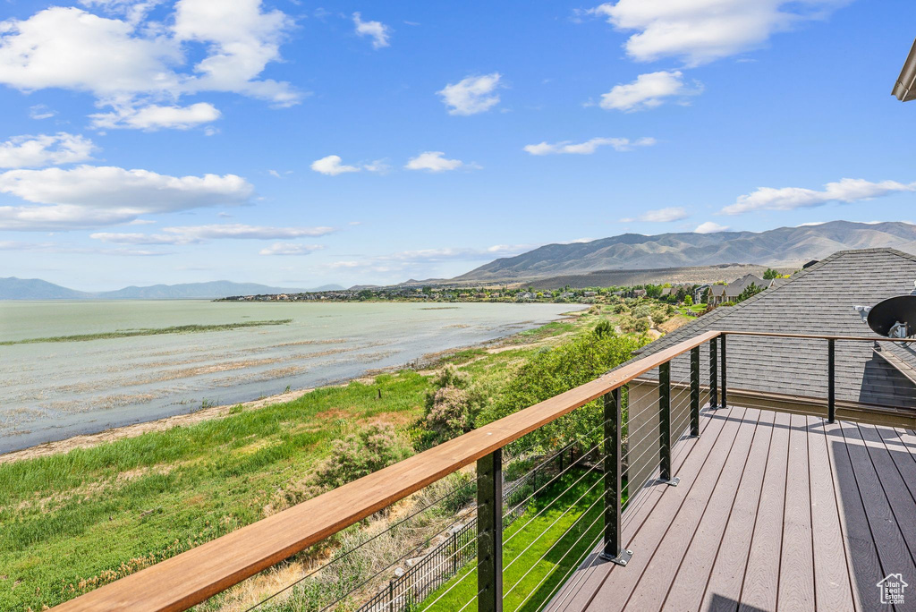 Wooden terrace featuring a water and mountain view