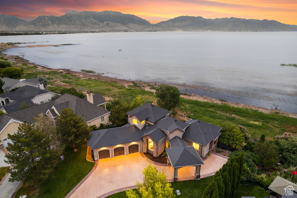 Aerial view at dusk featuring a water and mountain view