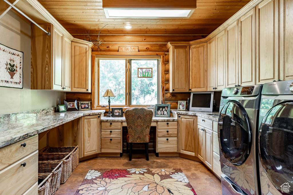 Laundry room featuring wood ceiling, cabinets, and washer and clothes dryer