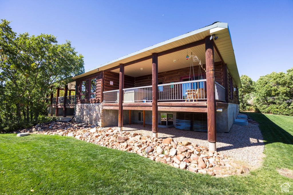 Rear view of property featuring a deck and a yard