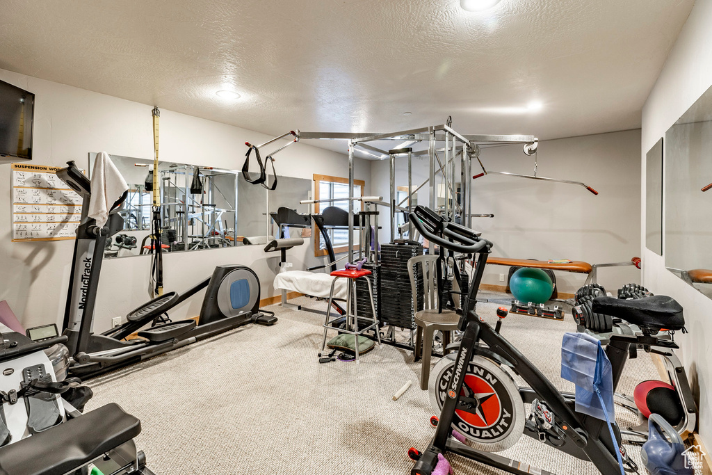 Exercise area with a textured ceiling and carpet floors