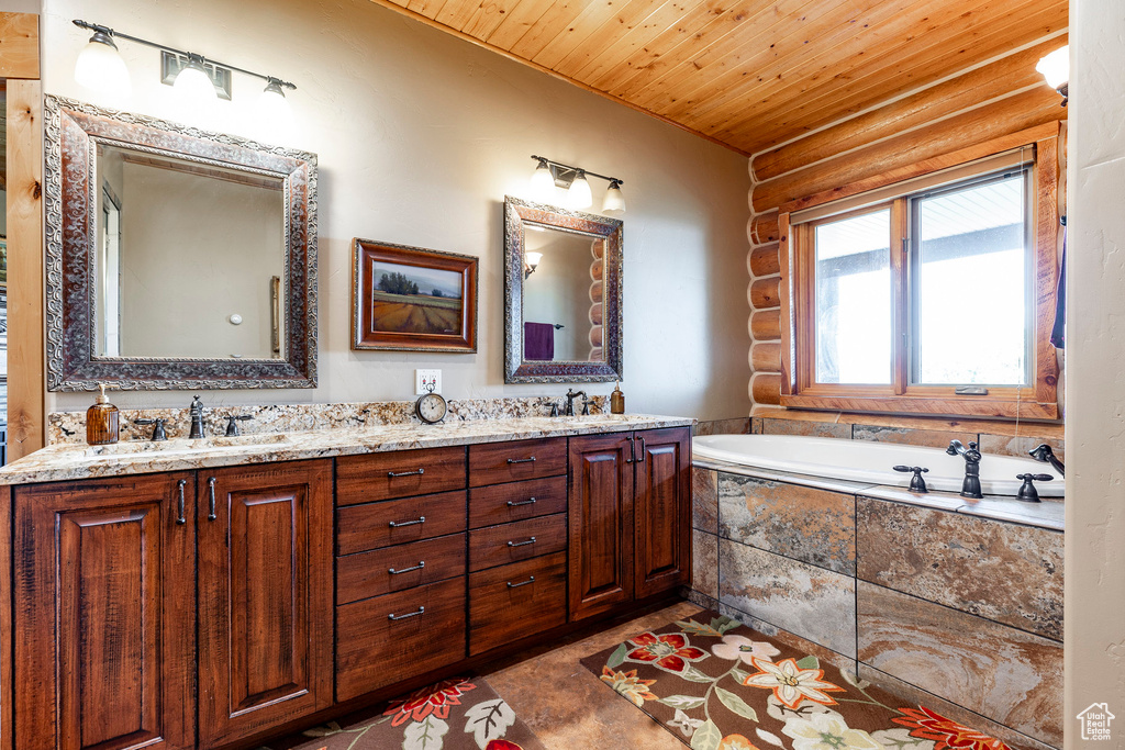 Bathroom with tile flooring, tiled tub, double vanity, and wood ceiling