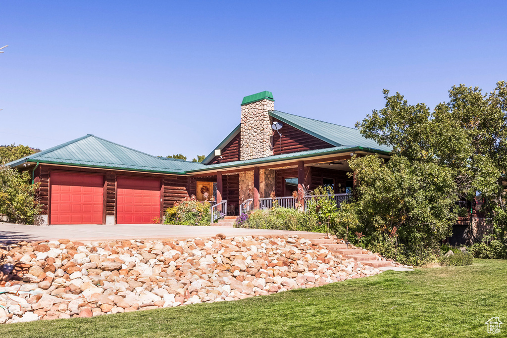 View of front facade with a garage, a front yard, and covered porch