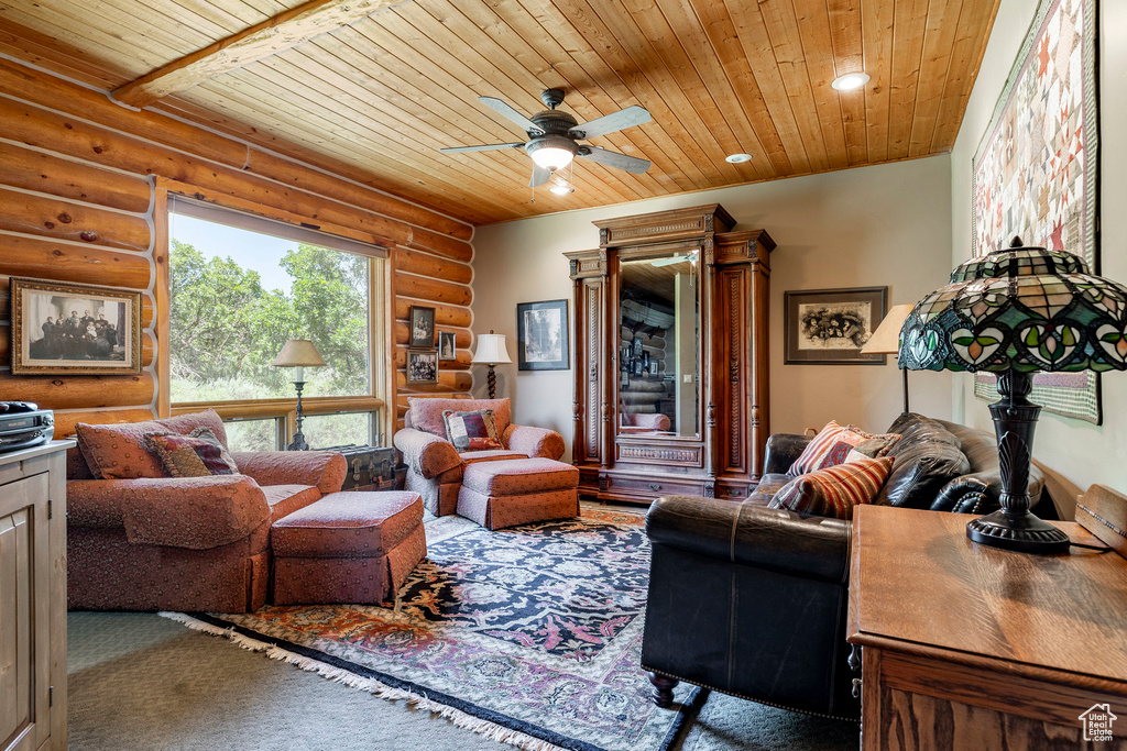 Living room featuring wooden ceiling, ceiling fan, and rustic walls