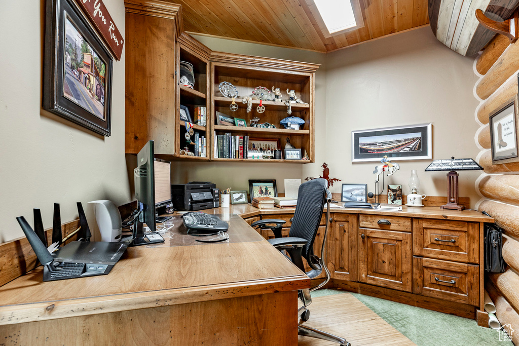 Carpeted home office with wood ceiling and a skylight