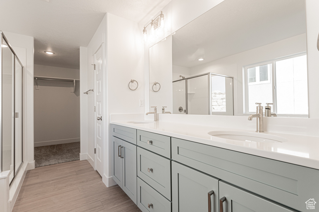 Bathroom featuring vanity, wood-type flooring, and an enclosed shower