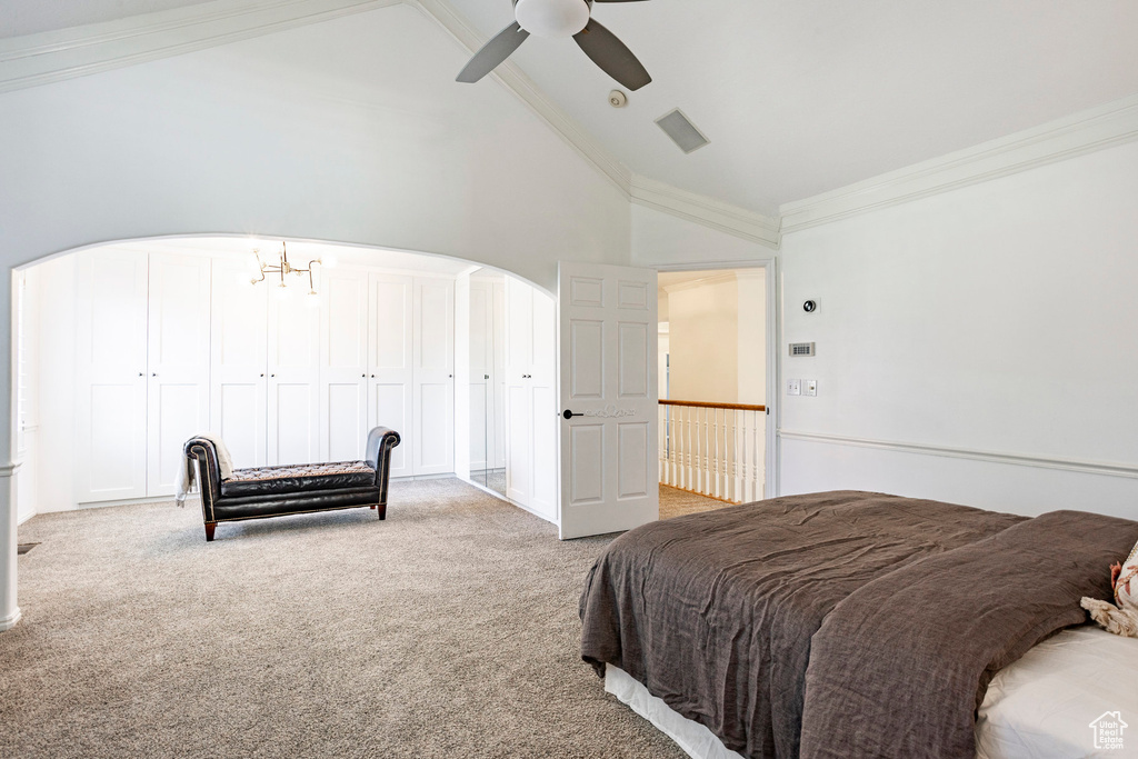 Carpeted bedroom featuring high vaulted ceiling, ornamental molding, ceiling fan, and a closet