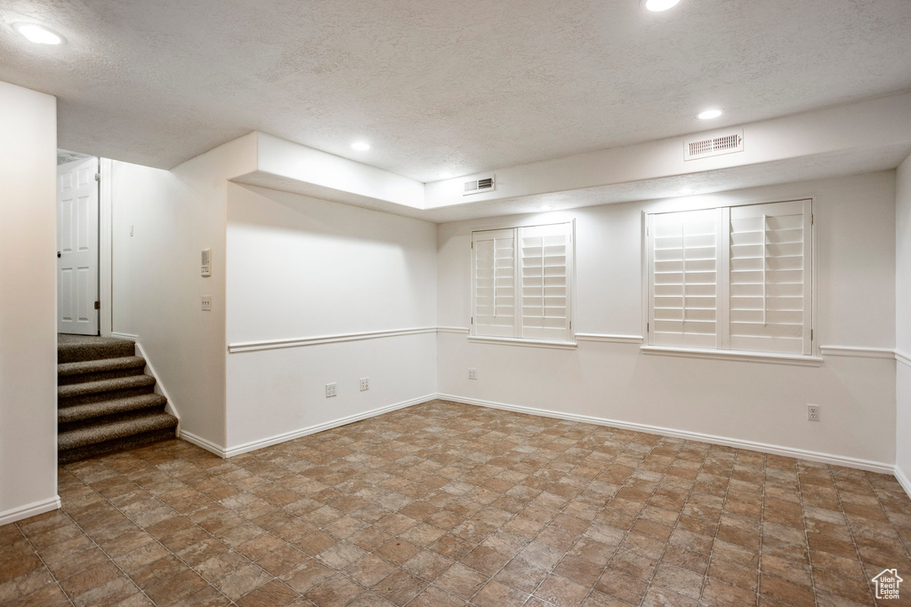 Unfurnished room featuring tile flooring and a textured ceiling