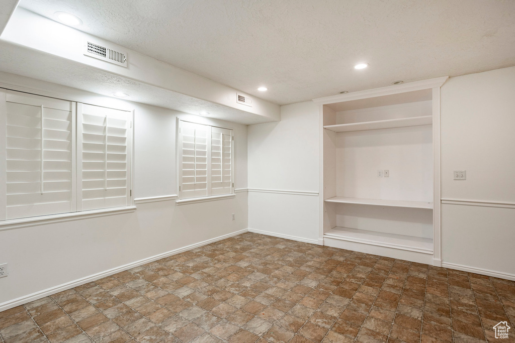 Unfurnished room with tile floors and a textured ceiling