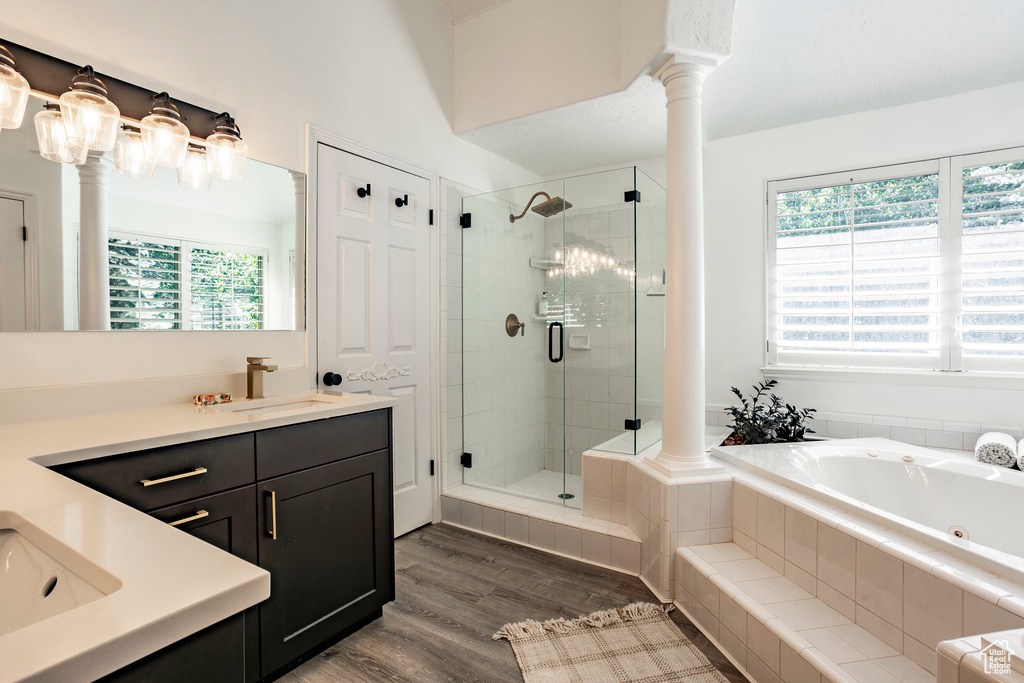 Bathroom with oversized vanity, a healthy amount of sunlight, hardwood / wood-style flooring, and independent shower and bath