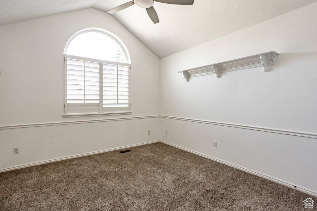 Spare room featuring lofted ceiling, carpet floors, and ceiling fan