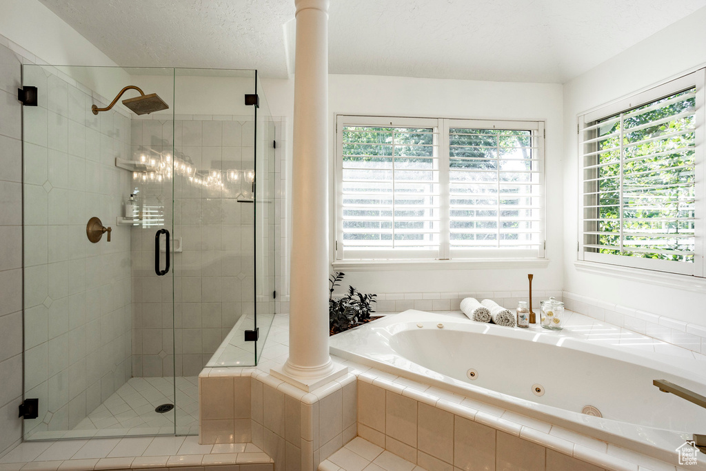 Bathroom featuring shower with separate bathtub and ornate columns