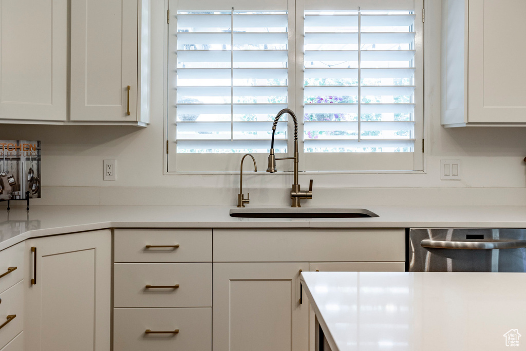 Kitchen featuring sink, white cabinets, and stainless steel dishwasher