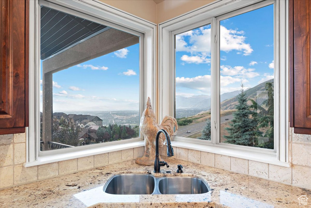 Kitchen with sink, a mountain view, and light stone counters