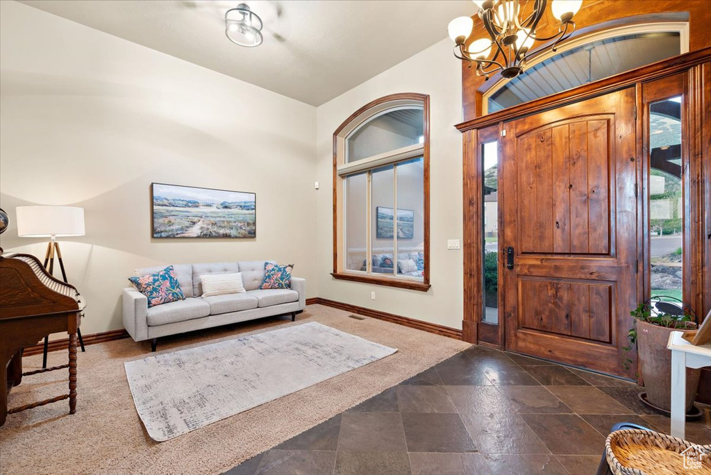 Tiled foyer entrance featuring a notable chandelier