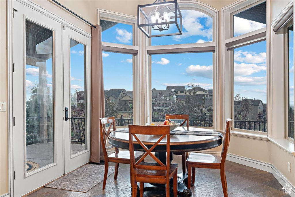 Dining area featuring a healthy amount of sunlight, an inviting chandelier, and tile floors