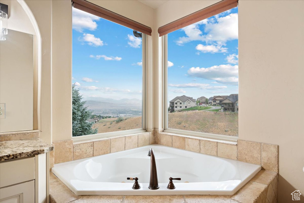 Bathroom featuring tiled bath and vanity