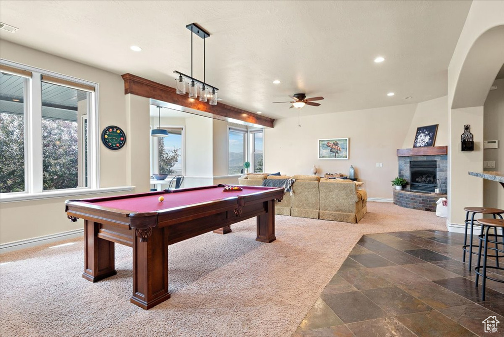 Game room with a fireplace, dark tile flooring, ceiling fan, and pool table