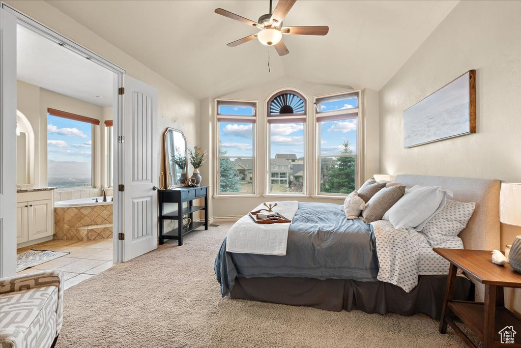 Carpeted bedroom featuring lofted ceiling, ceiling fan, and ensuite bath