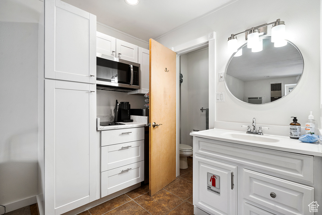 Bathroom featuring tile flooring, oversized vanity, and toilet