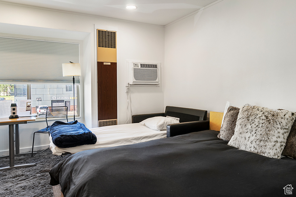 Bedroom featuring ornamental molding, carpet flooring, and a wall mounted AC