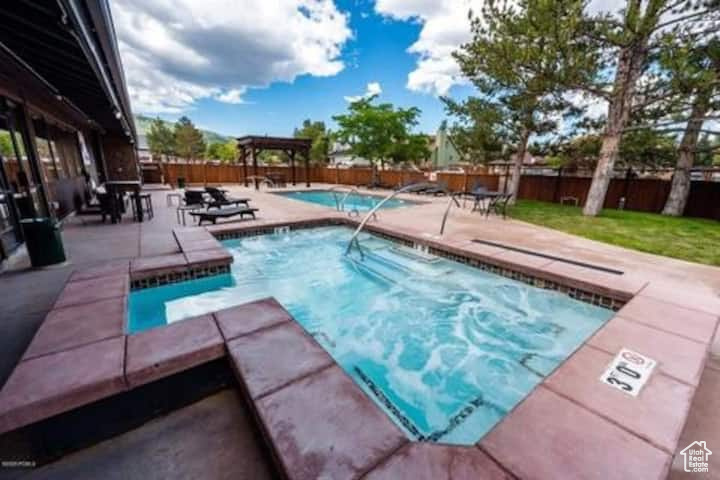 View of swimming pool with an in ground hot tub