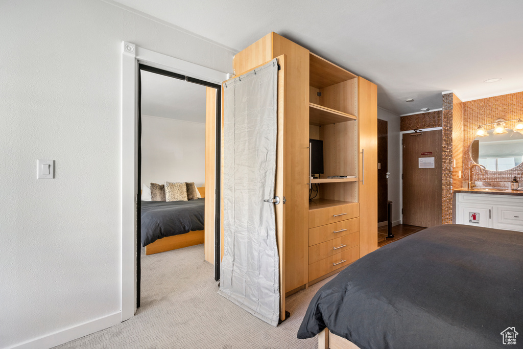 Bedroom featuring light carpet and connected bathroom