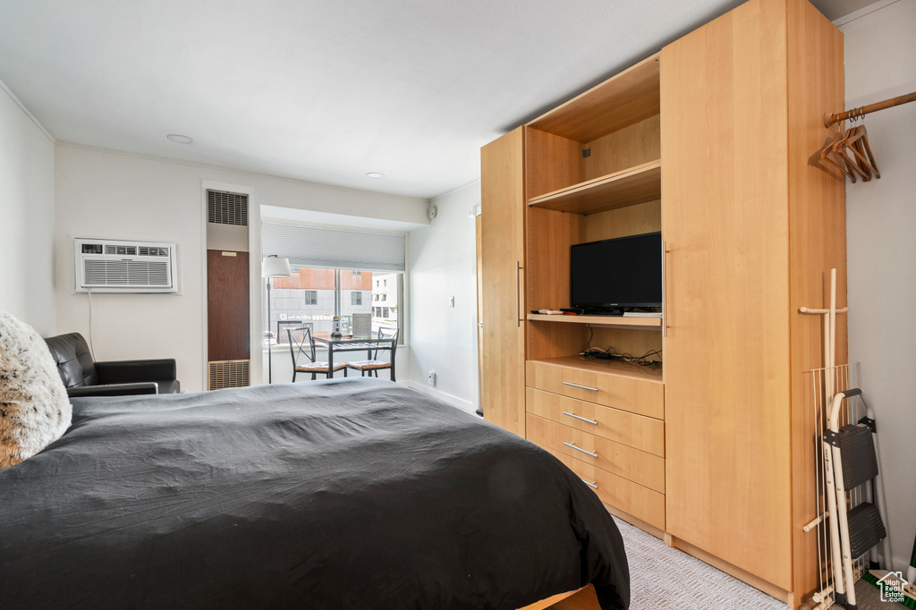 Bedroom featuring light carpet and a wall mounted air conditioner