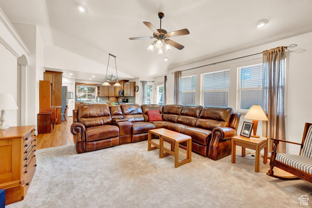 Living room featuring ceiling fan, vaulted ceiling, and light colored carpet