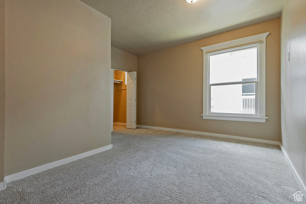 Carpeted spare room with a textured ceiling