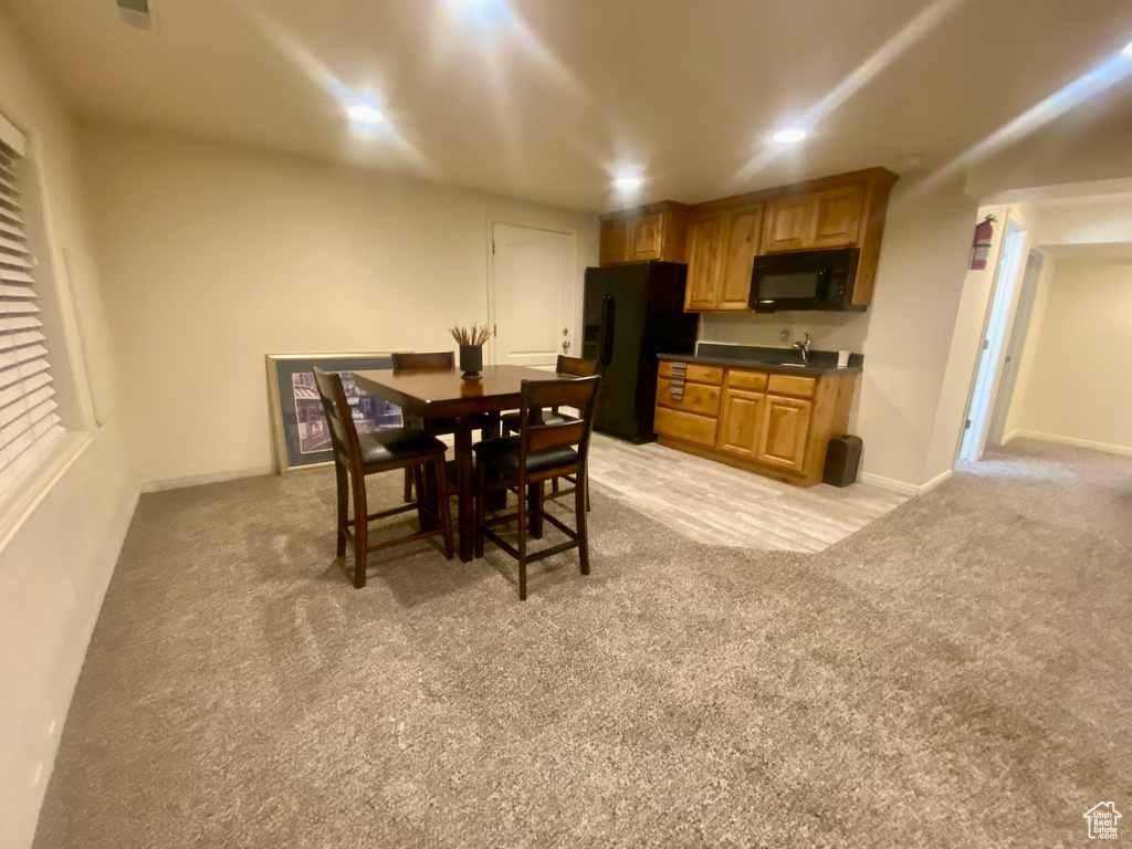 Dining space with sink and light colored carpet