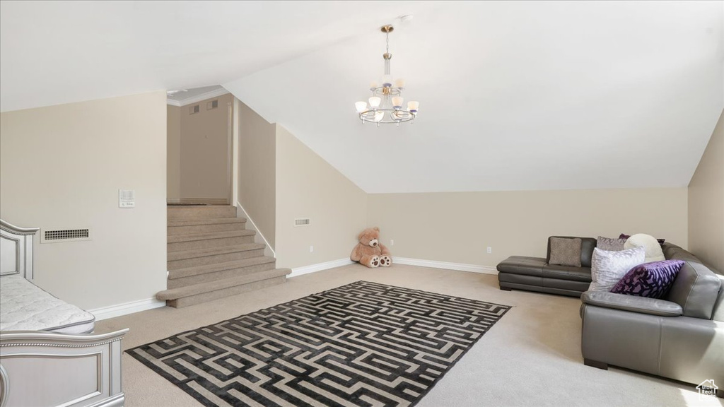 Living room with a chandelier, lofted ceiling, and carpet