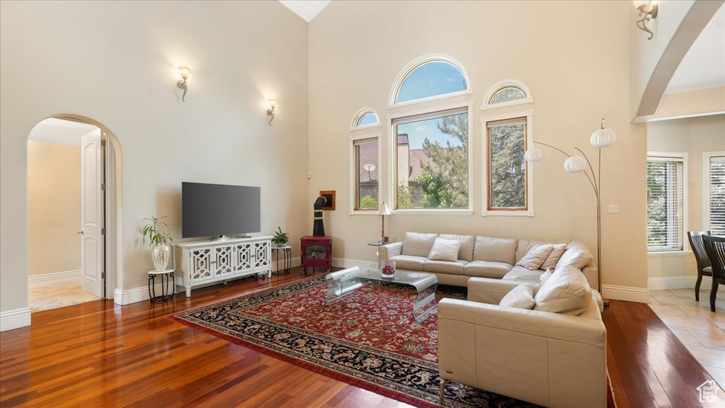 Living room with a high ceiling, hardwood / wood-style flooring, and plenty of natural light