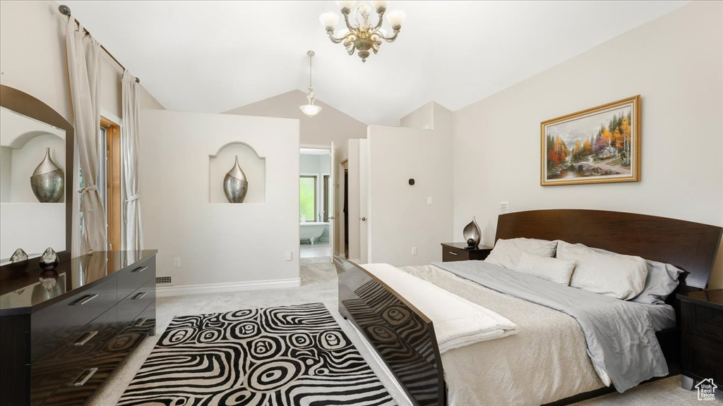 Carpeted bedroom featuring a notable chandelier and vaulted ceiling