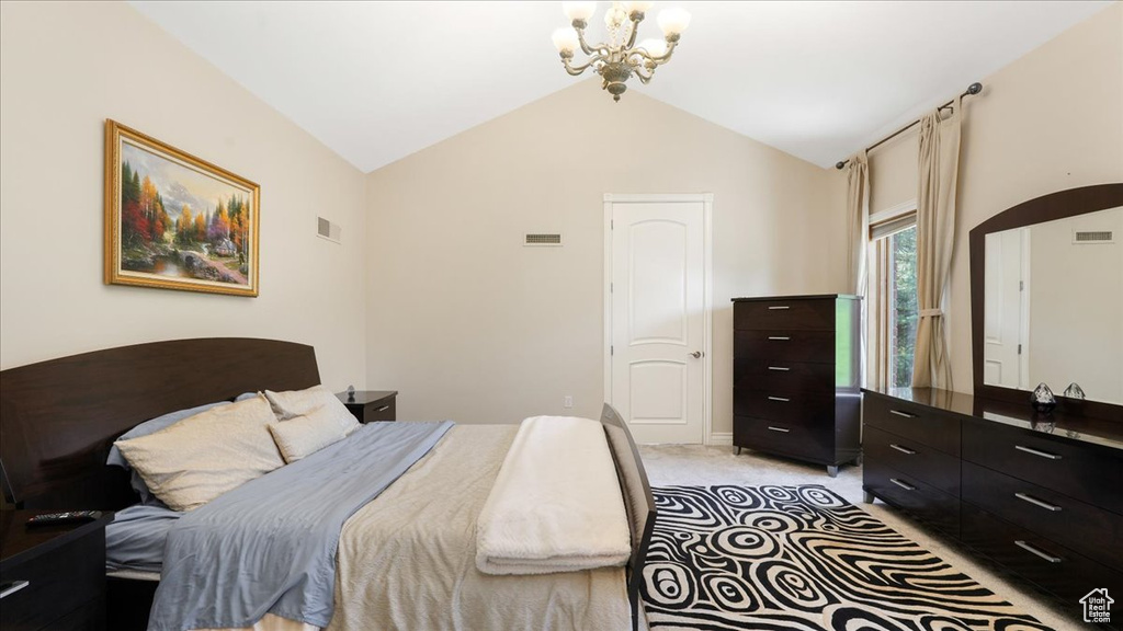 Carpeted bedroom with an inviting chandelier and lofted ceiling