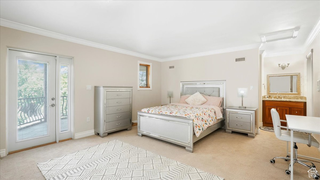 Carpeted bedroom featuring access to outside, sink, ornamental molding, and ensuite bathroom