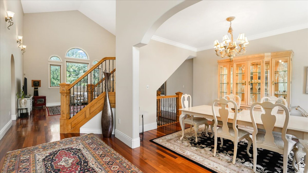 Dining space featuring vaulted ceiling, a chandelier, dark hardwood / wood-style floors, and crown molding