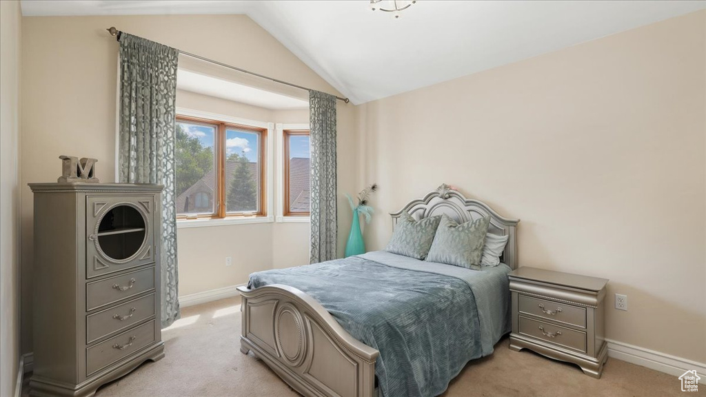 Carpeted bedroom featuring vaulted ceiling