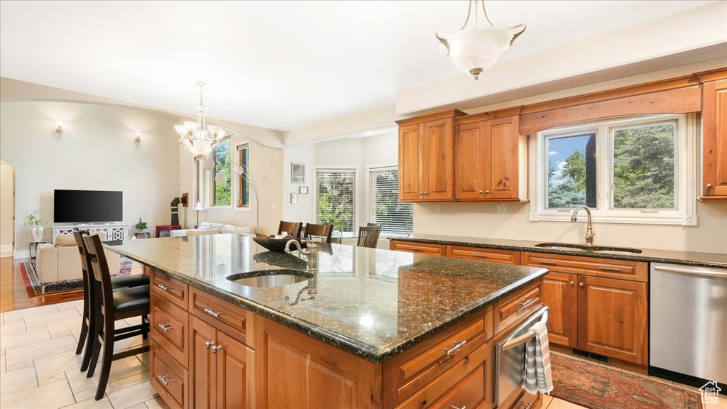 Kitchen with plenty of natural light, sink, a kitchen island with sink, and appliances with stainless steel finishes