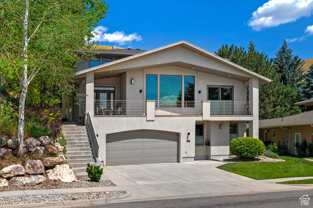 View of front of house featuring a garage and a balcony