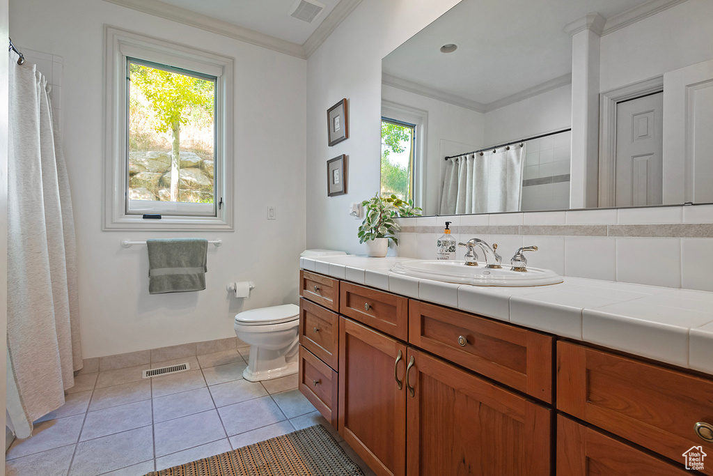 Bathroom featuring crown molding, tile flooring, oversized vanity, tasteful backsplash, and toilet