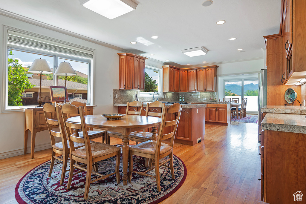 Dining space featuring ornamental molding and light wood-type flooring