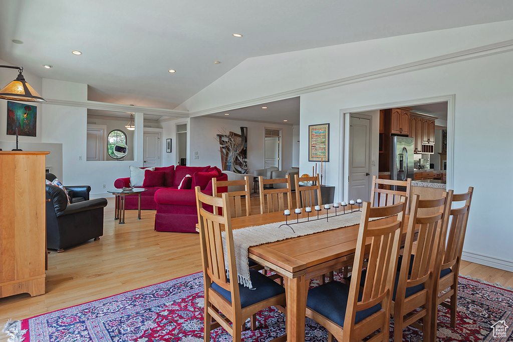 Dining room with vaulted ceiling and light wood-type flooring