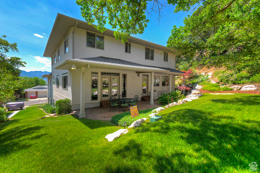 Back of property featuring a patio and a yard