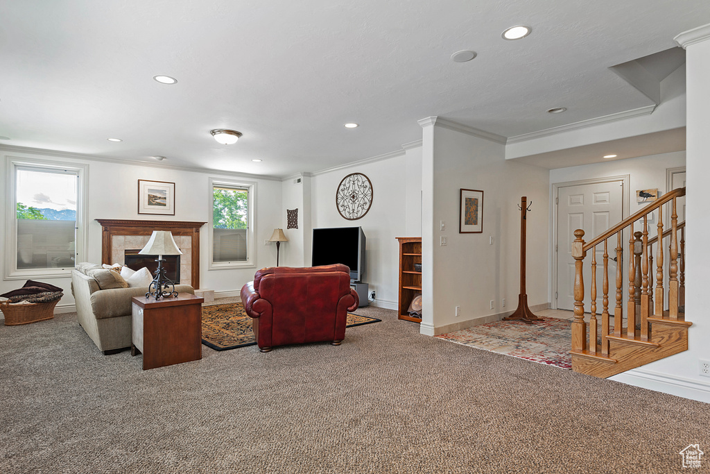 Carpeted living room with a tile fireplace and crown molding